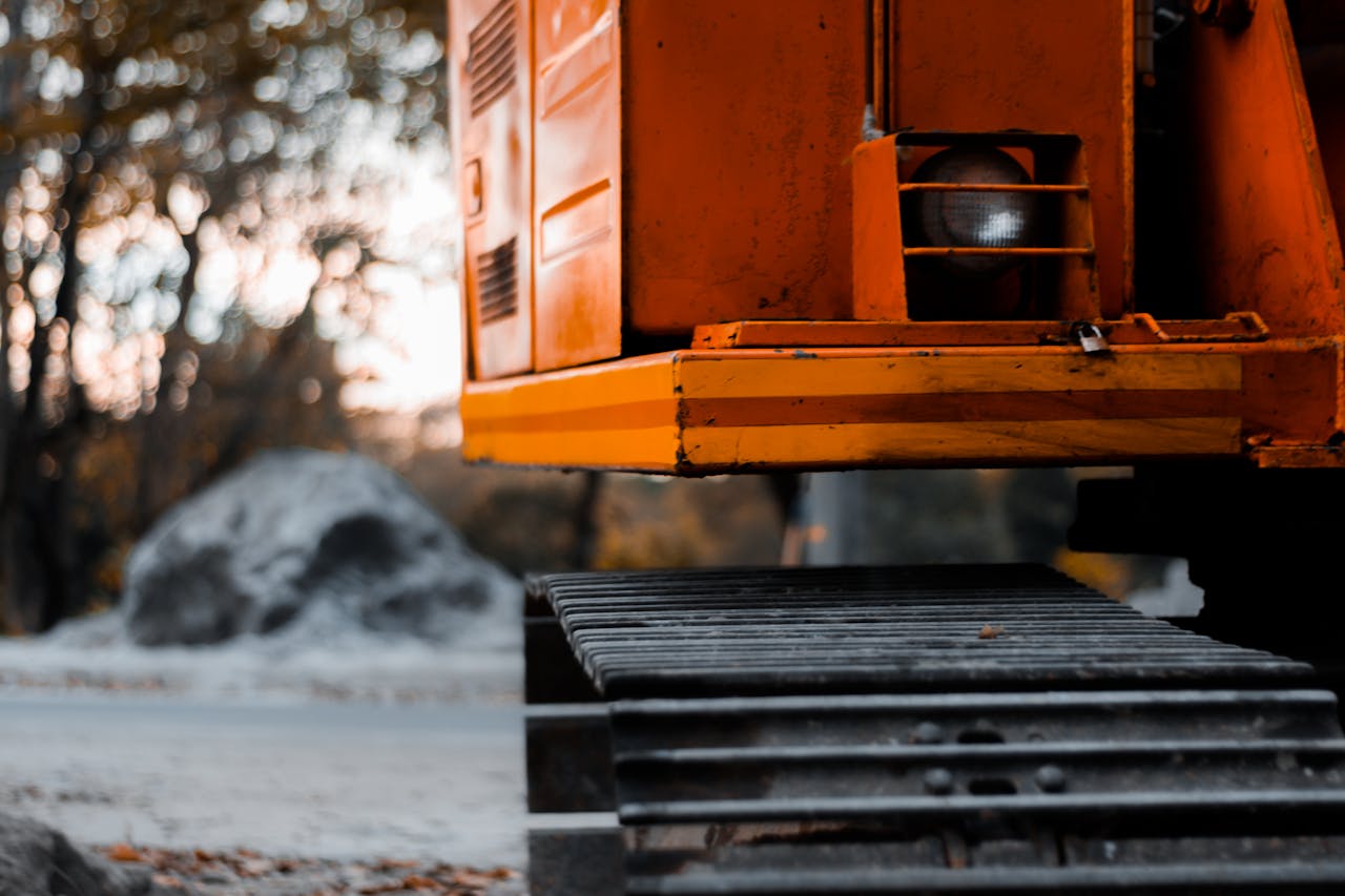 Home Close-up shot of an orange excavator with tracks in an outdoor setting during the day.